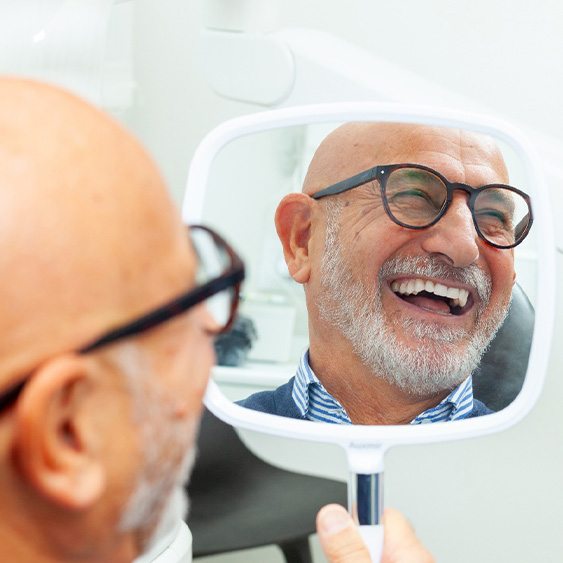 A man smiling at his new dentures