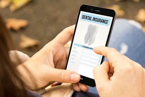 A woman looking at her dental insurance policy on a smartphone