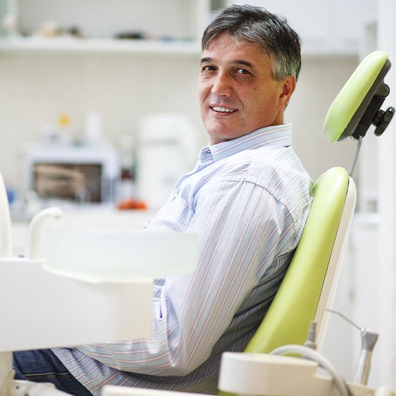 Man smiling while sitting in treatment chair