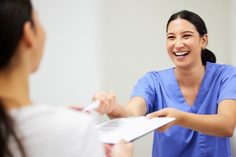 A woman filling out paperwork at a dentist’s office