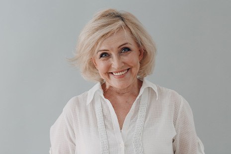 Woman in white shirt with short hair smiling