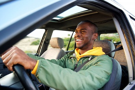 Man smiles while driving
