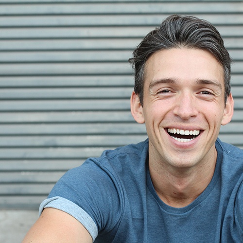 closeup of young man smiling after getting a dental bridge 