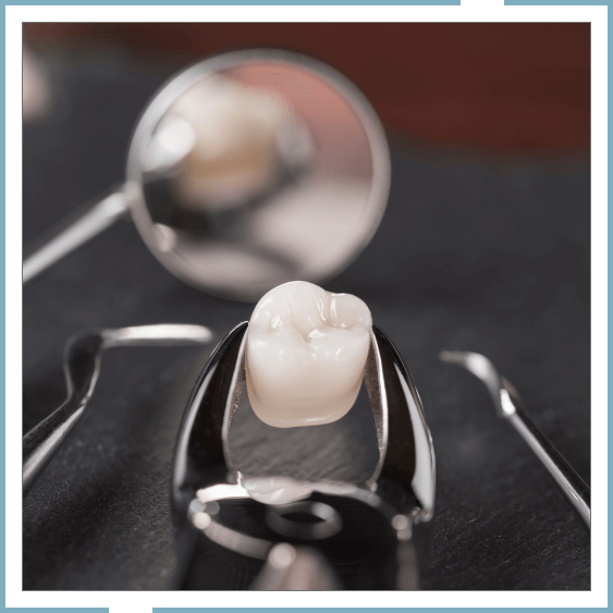 Forceps holding tooth lying next to dental mirror