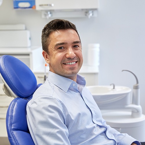 Man smiling while sitting in treatment chair